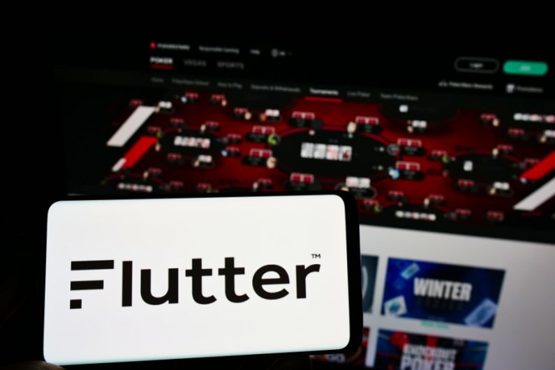 Flutter-logo på en smartphone med PokerStars i baggrunden
