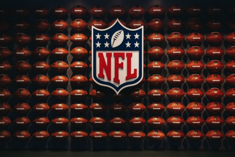 Логотип НФЛ перед стеной футбольных мячей