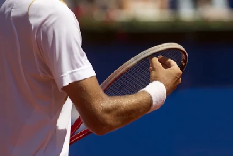 Tennis player checking his racquet strings