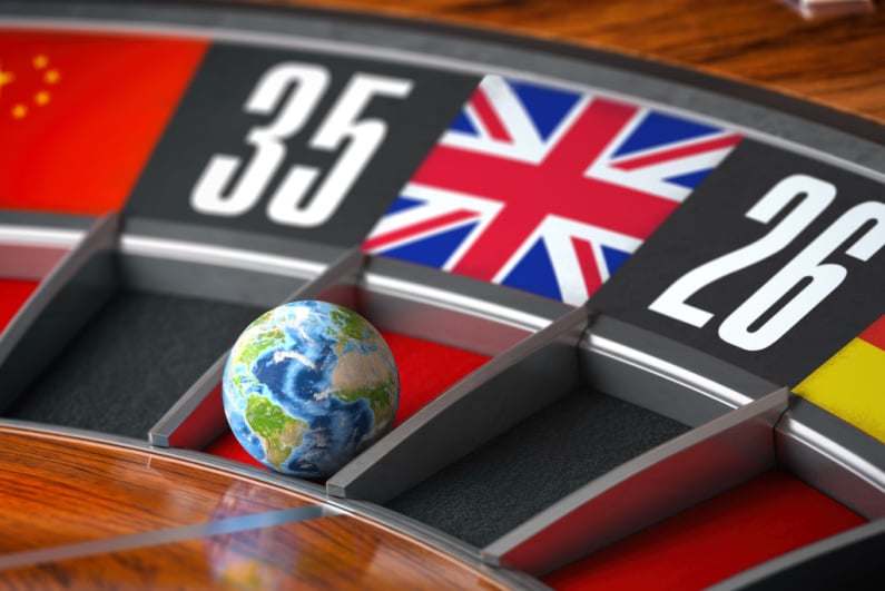 Koło ruletki z kulą Ziemi lądującą na przestrzeni z flagą Wielkiej Brytanii