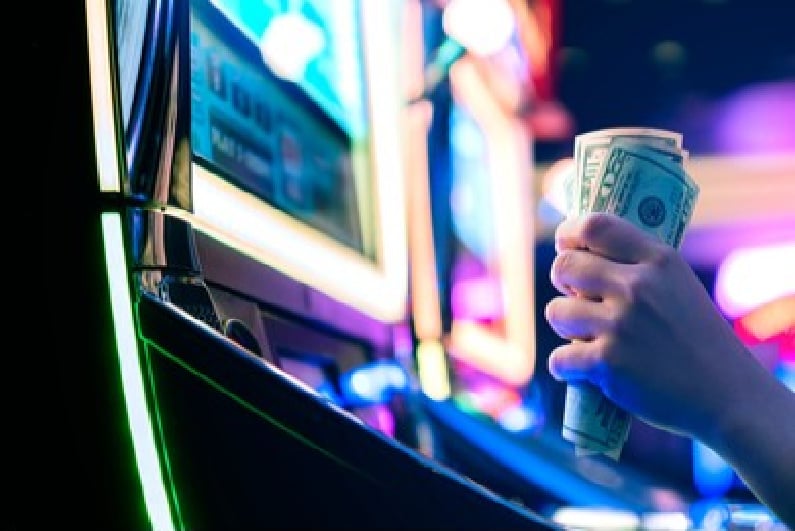 Nævefuld kontanter ved en spilleautomat