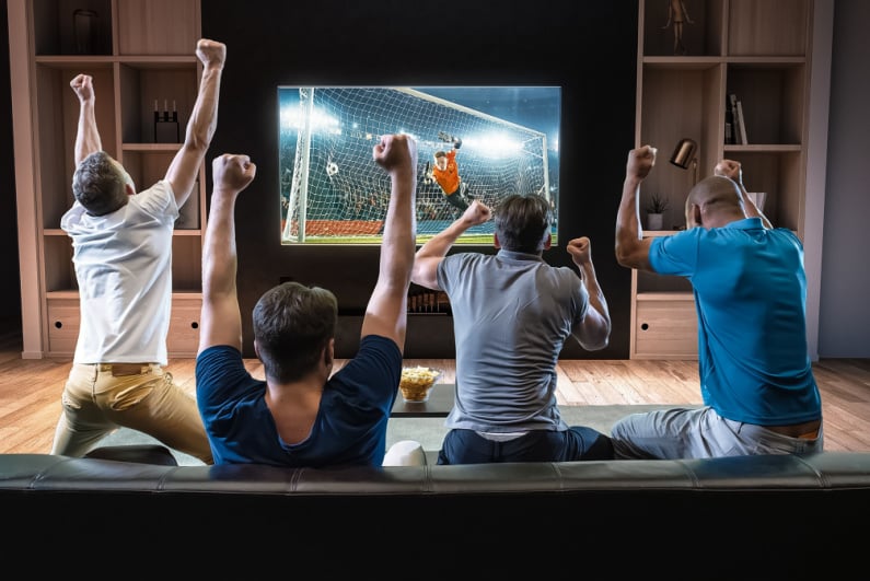 Four men celebrating watching soccer