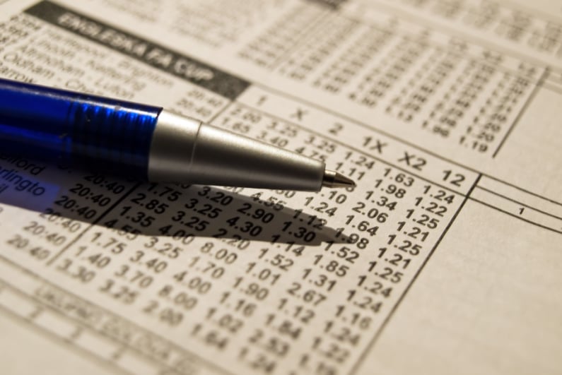 Closeup of pen on betting odds sheet