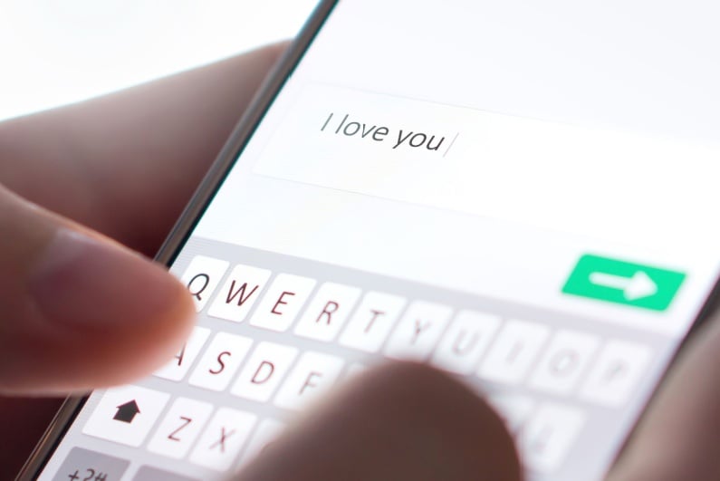 Osoba pisząca „Kocham cię” w wiadomości tekstowej