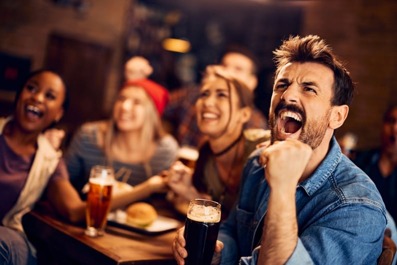 Ludzie pijący i oglądający sport