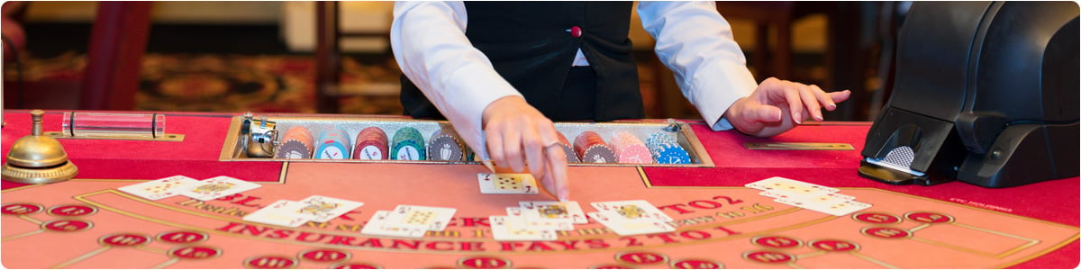Bild eines Casino-Dealers in Las Vegas, der Karten auf einen Blackjack-Tisch legt